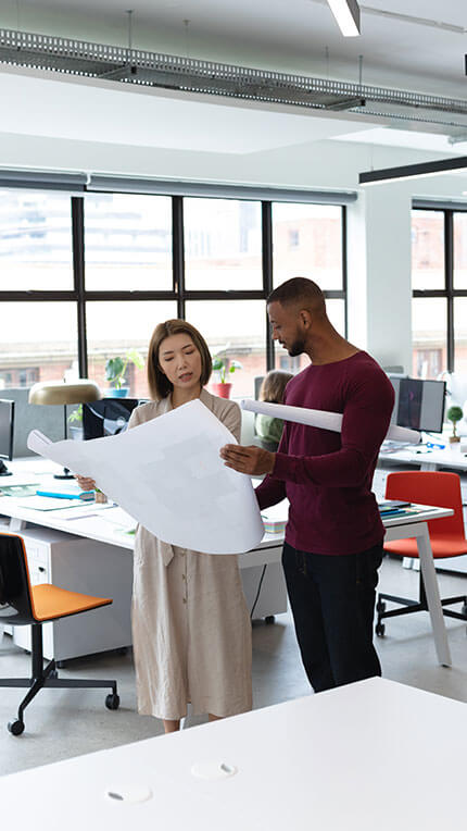 Office staff looking at expansion plans from a business loan